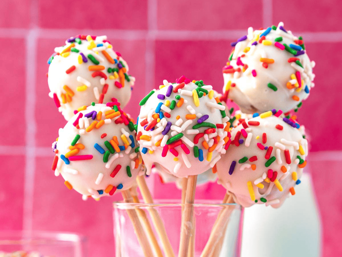 A handful of small frosted cake balls in glass.
