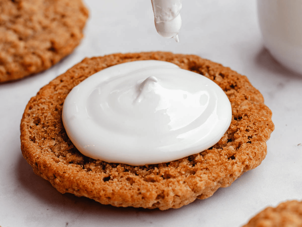 Whipped topping piped on oatmeal cookie.
