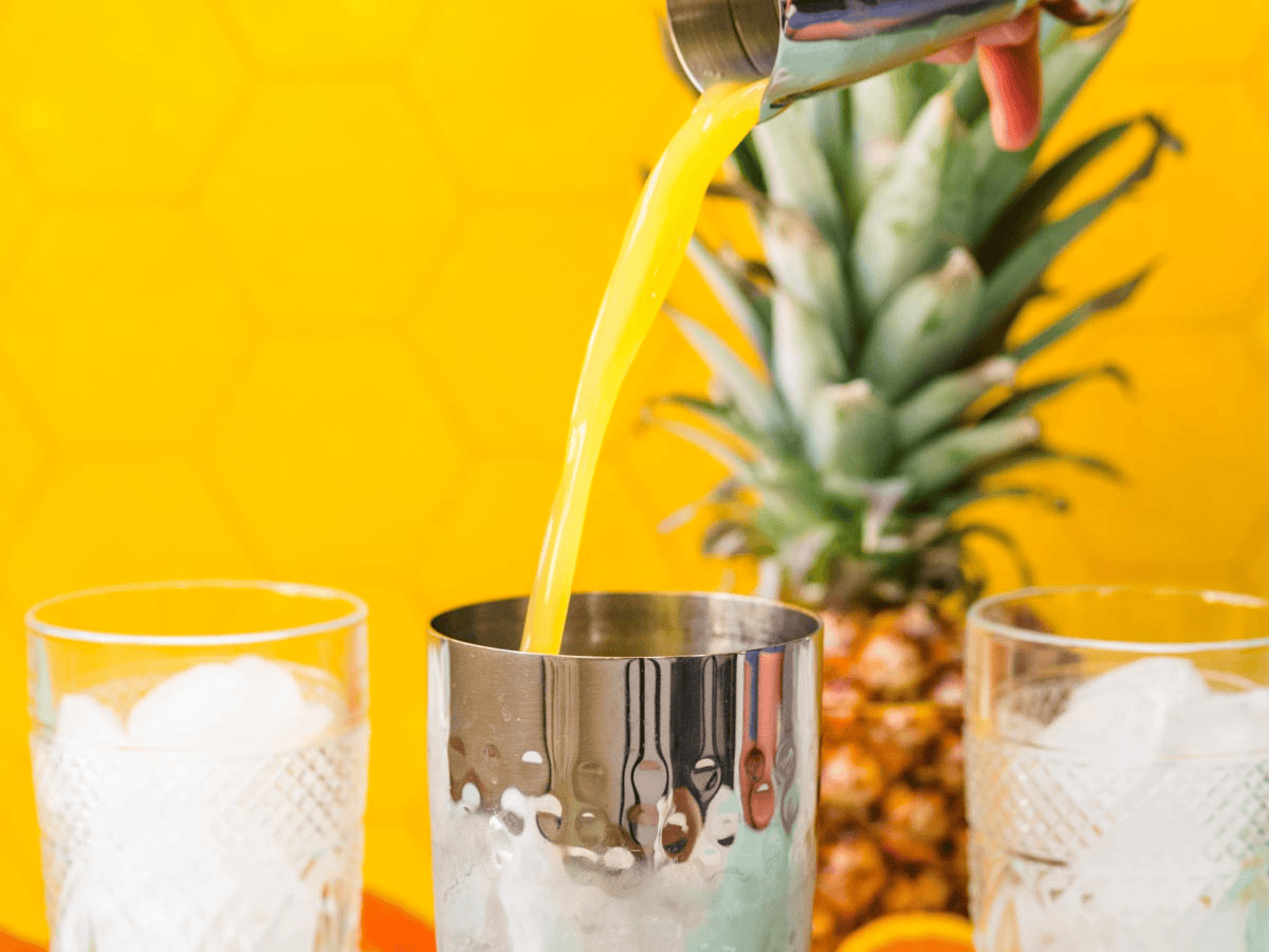 Juice being poured into cocktail shaker.