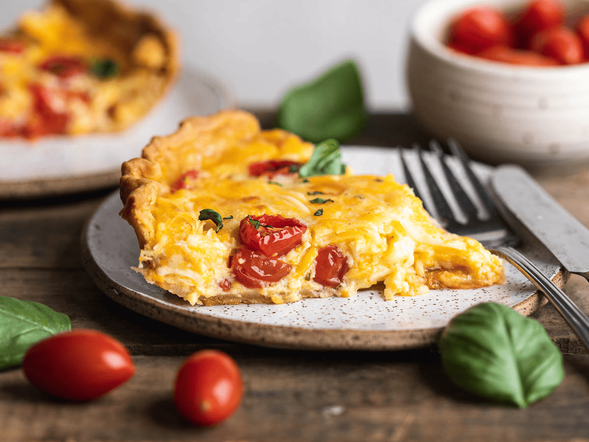A slice of savory pie on a white plate with a fork.