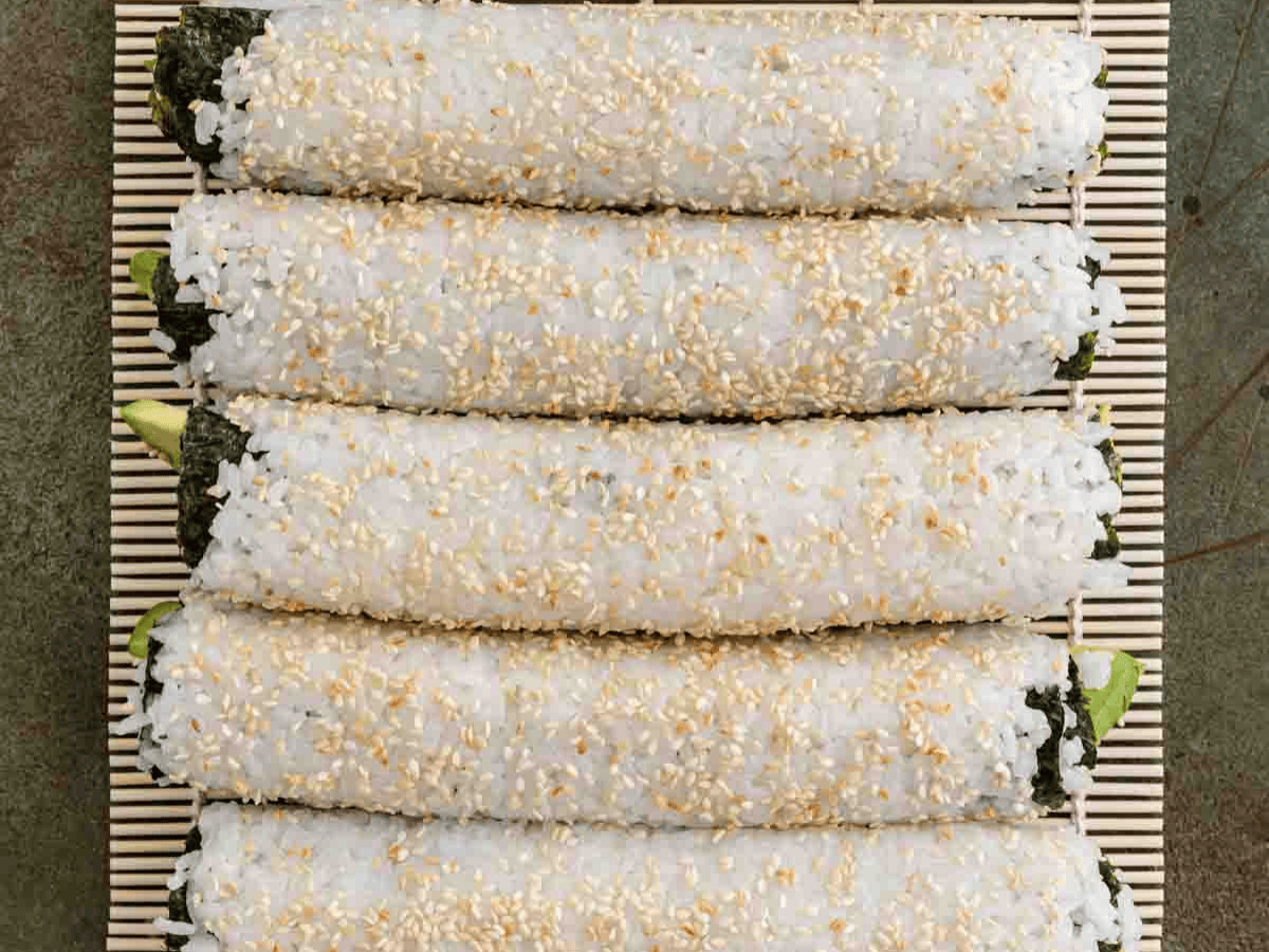 Uncut sushi roll with sesame seed topping.