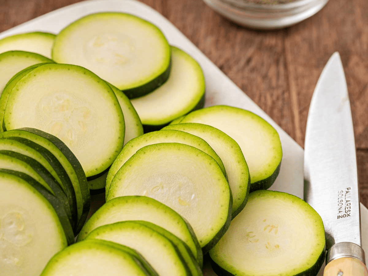 Sliced zucchini on cutting board.