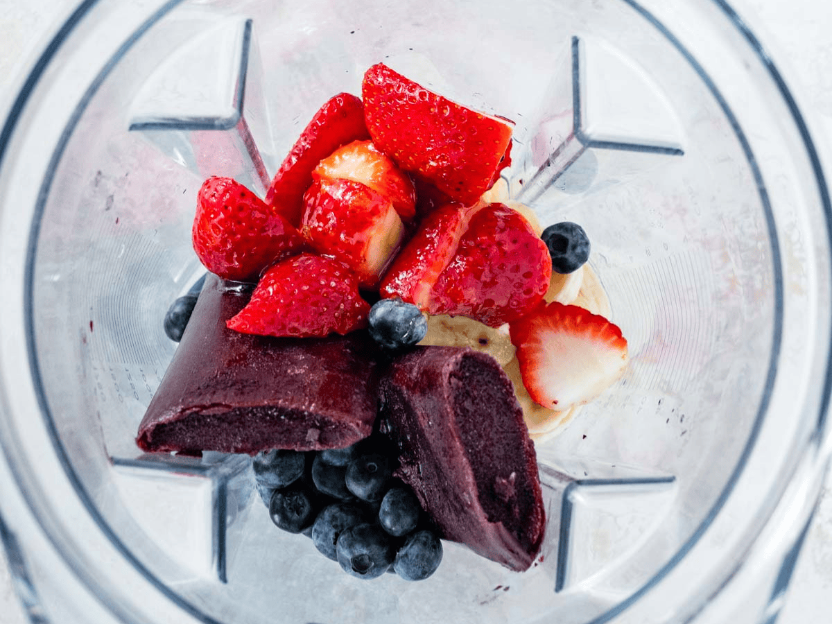 Unblended fruit and berries in blender.