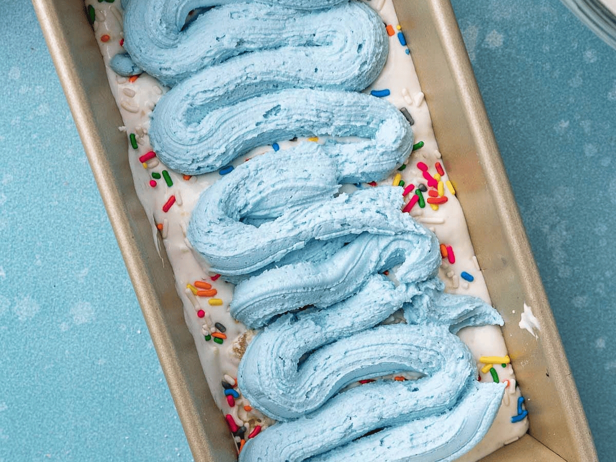 Layered frozen dessert with blue icing in the middle.