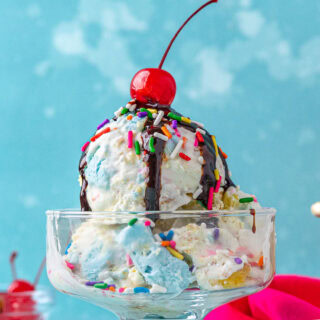 Sundae dish with ice cream, chocolate syrup, and cherry.