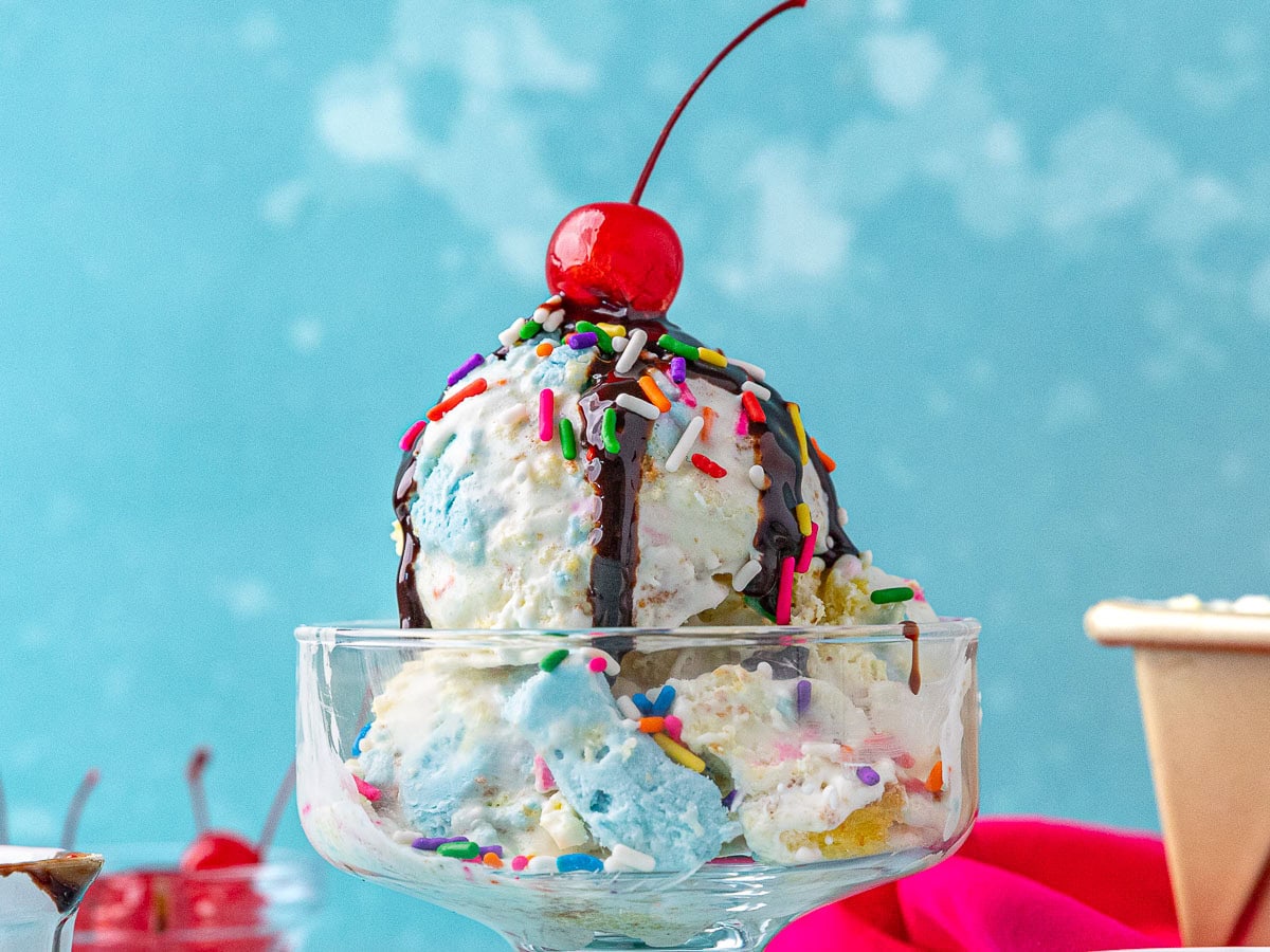 Sundae dish with ice cream, chocolate syrup, and cherry.