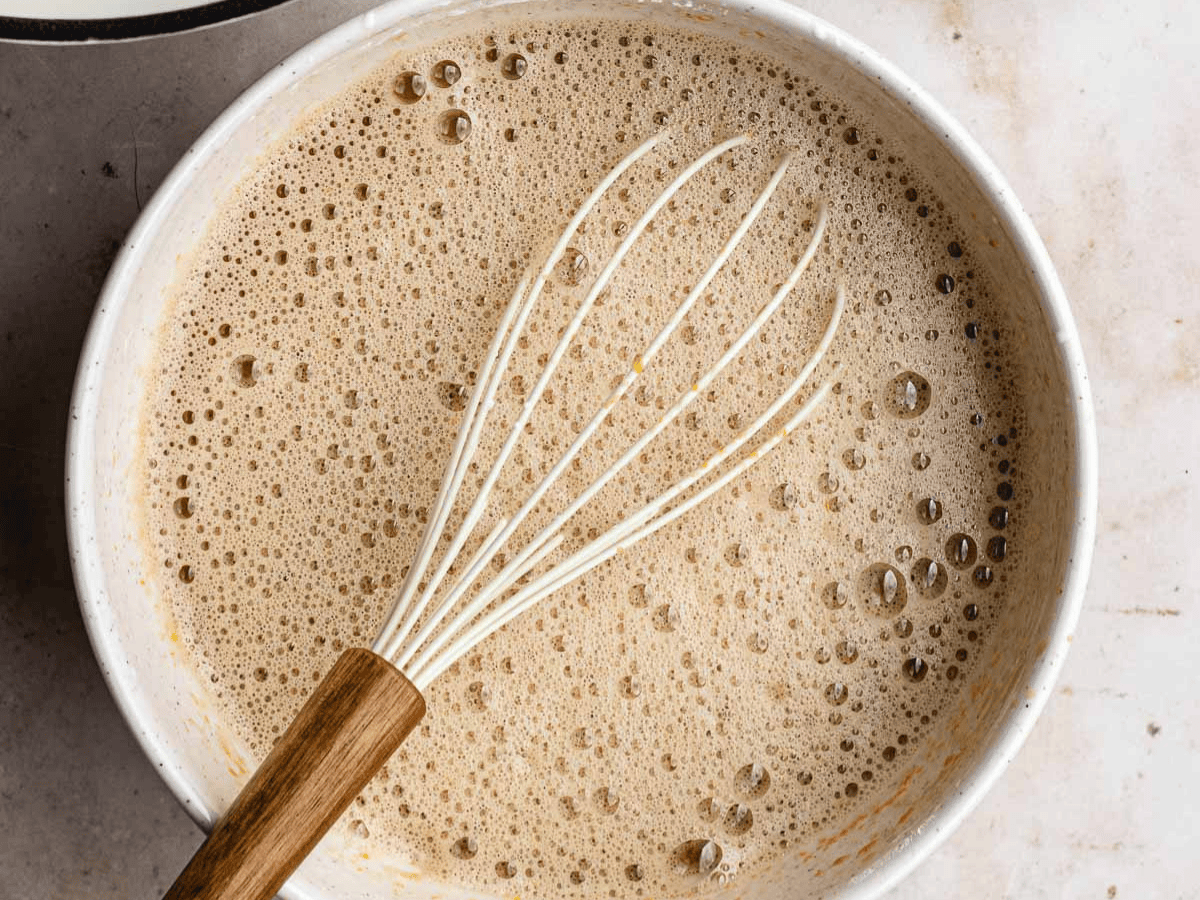 Milk, sugar, and other ingredients heating in pan.