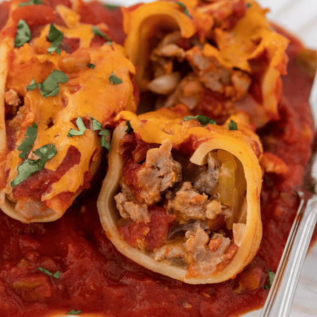 Close up of pasta stuffed with meat, cheese and red sauce.