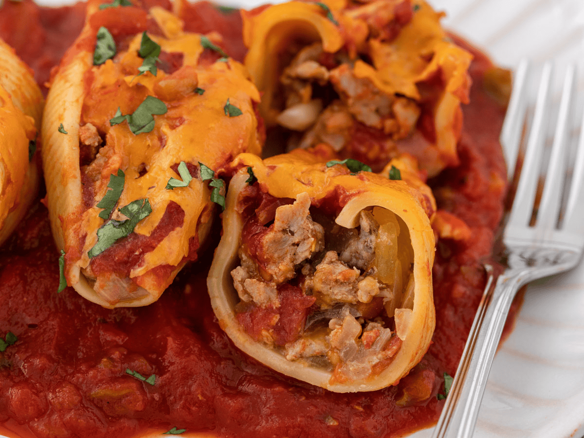 Close up of pasta stuffed with meat, cheese and red sauce.