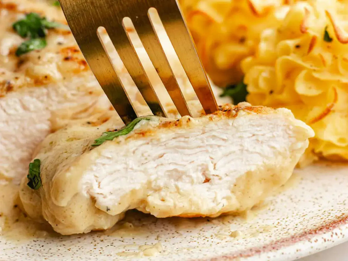Close up of a slice of poultry being pierced with a fork