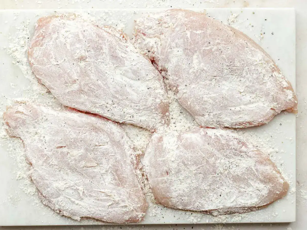 Raw chicken covered in a white powder.