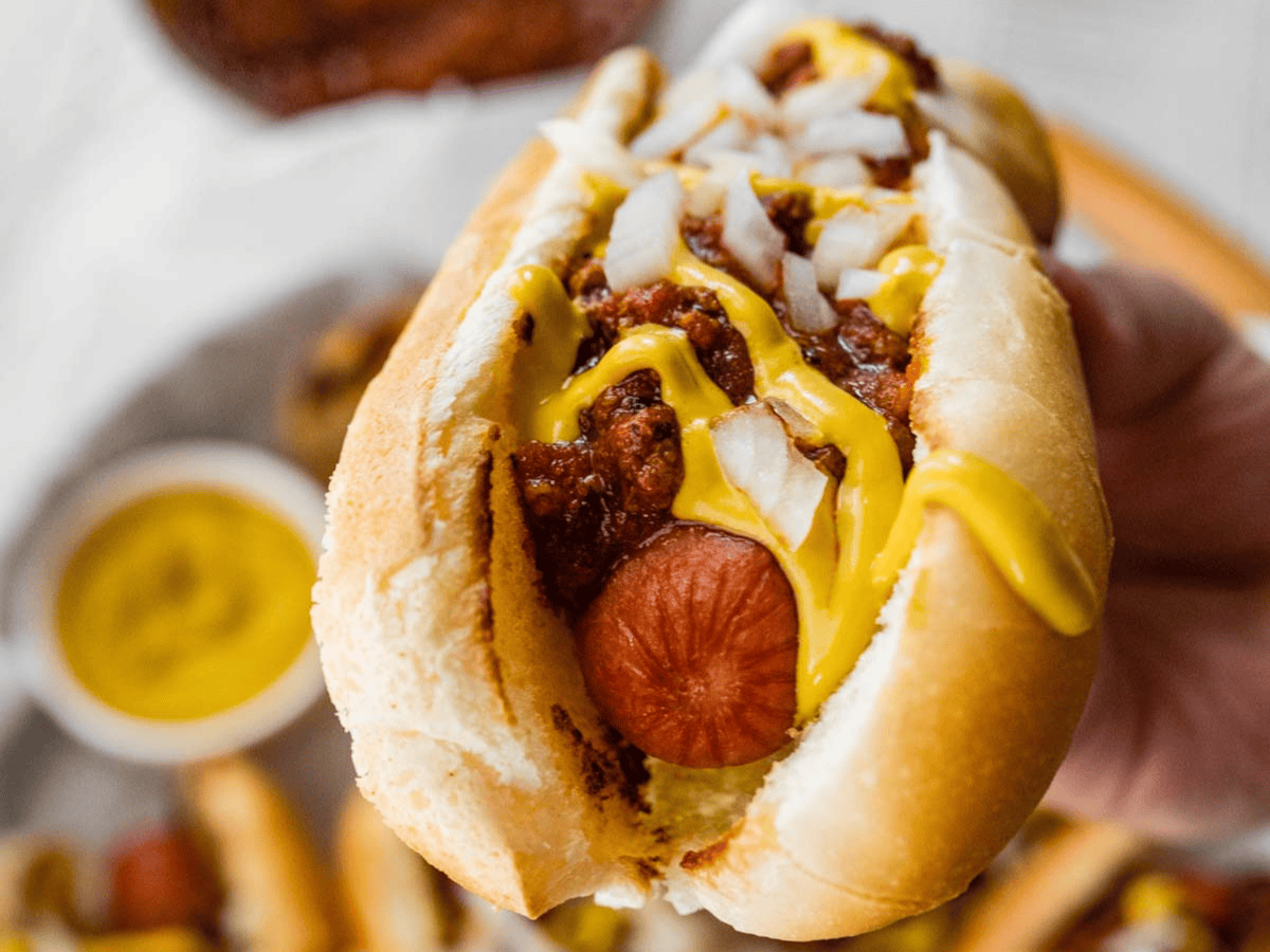 Hot dog in bun with toppings.