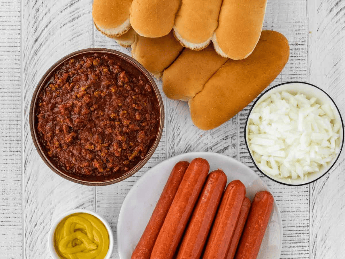 Hot dogs, buns, onions, mustard, and chili.
