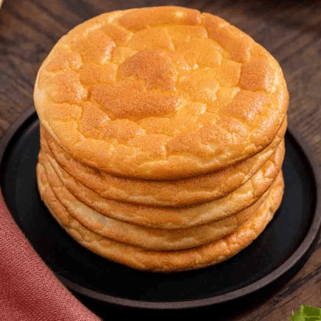 Top view of a stack of round tanned colored bread.