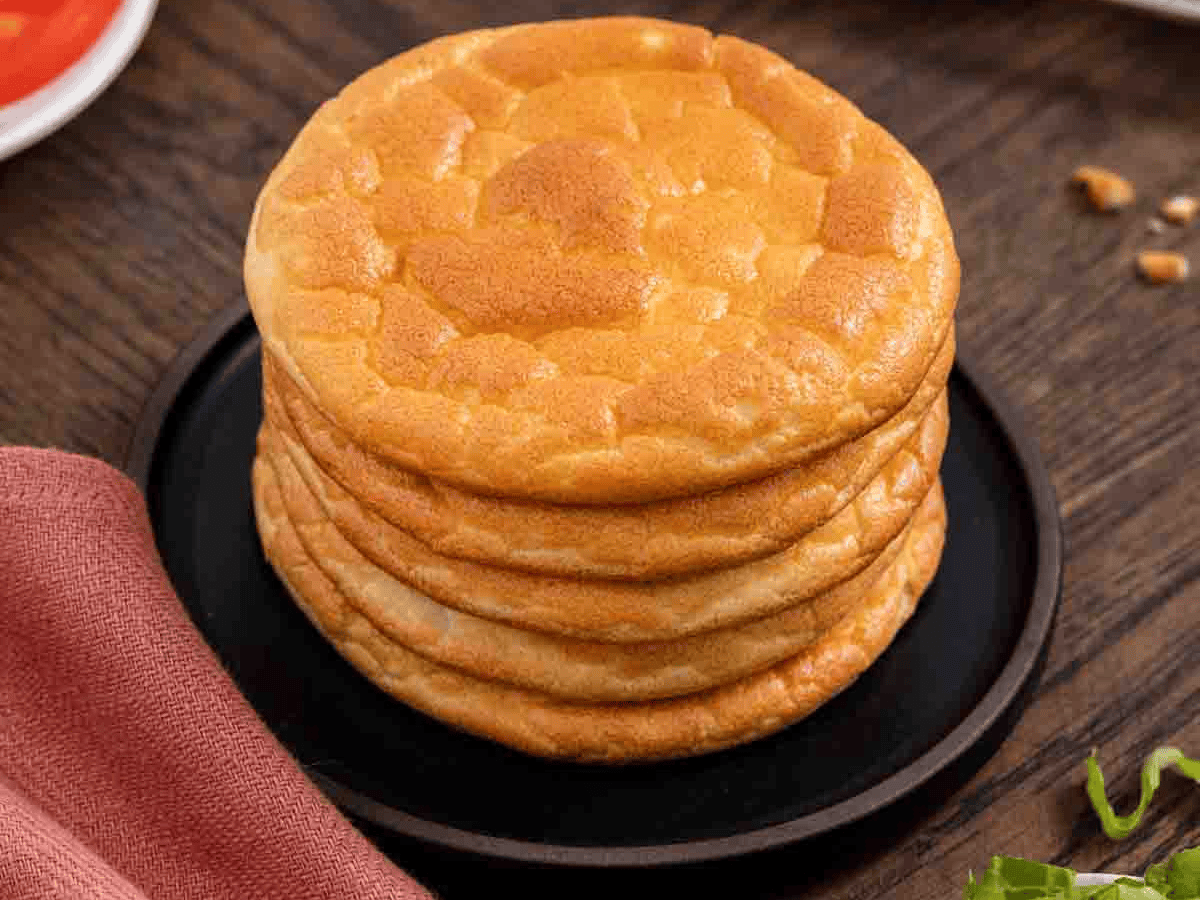 Top view of a stack of round tanned colored bread.