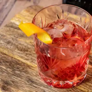 Cocktail in rocks glass with orange twist.