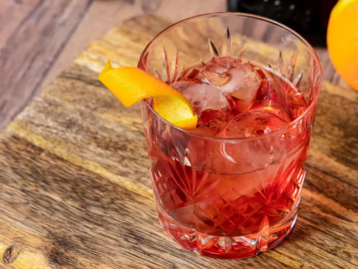 Cocktail in rocks glass with orange twist.
