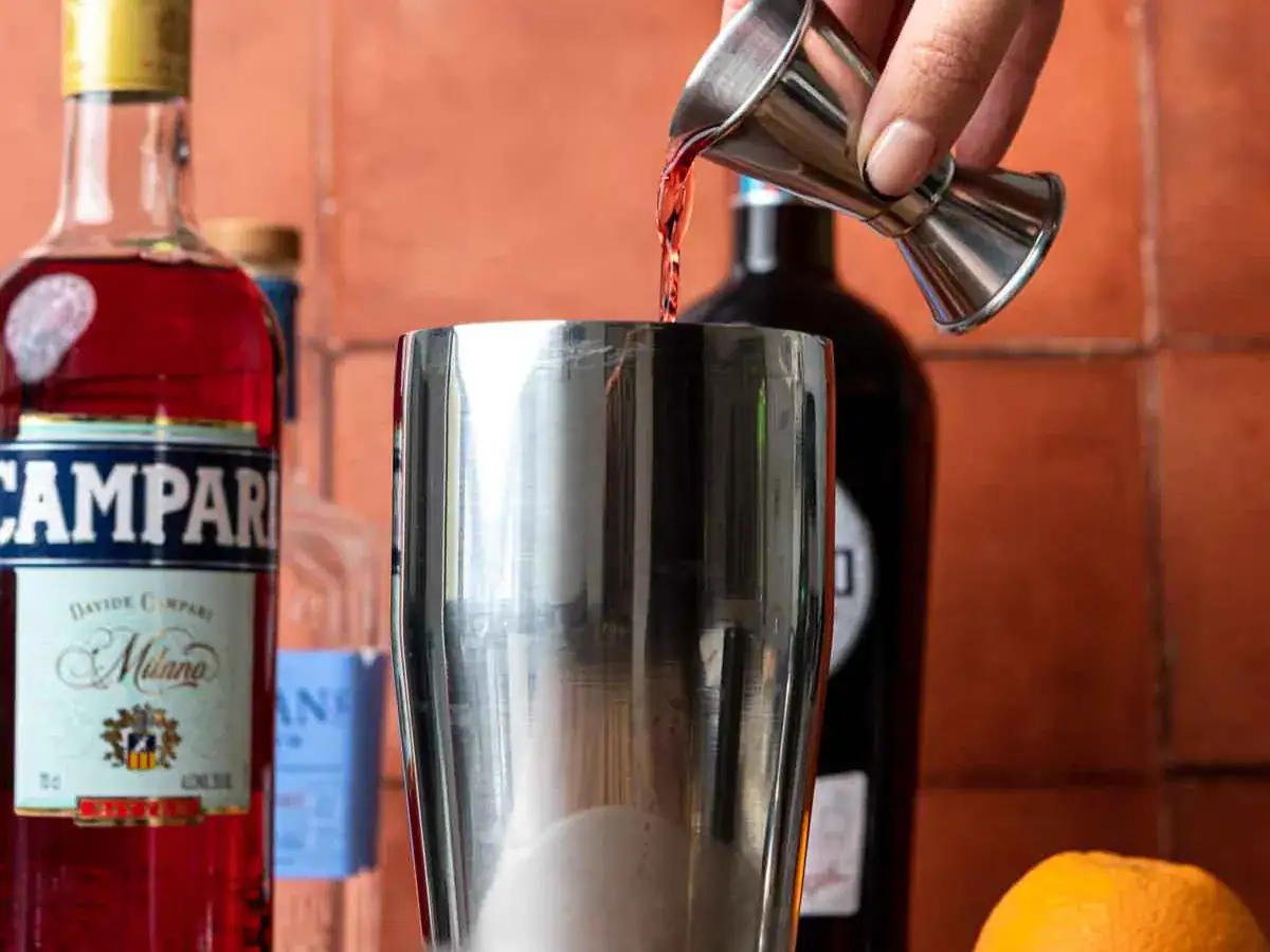 Campari being poured into shaker.