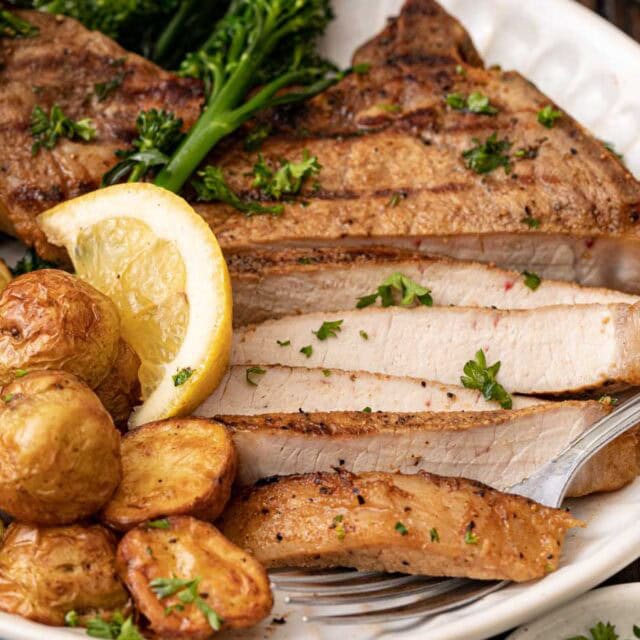 Grilled pork on dinner plate with potatoes.