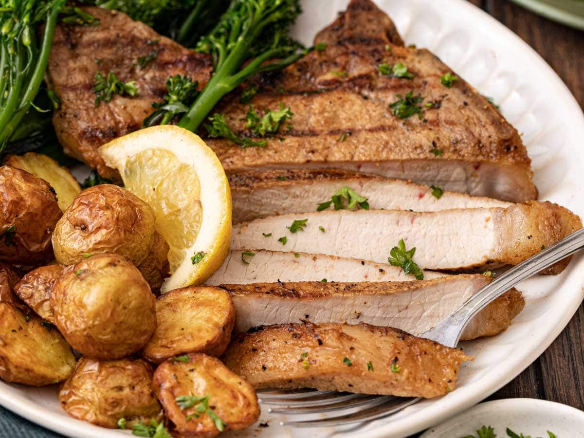 Grilled pork on dinner plate with potatoes.