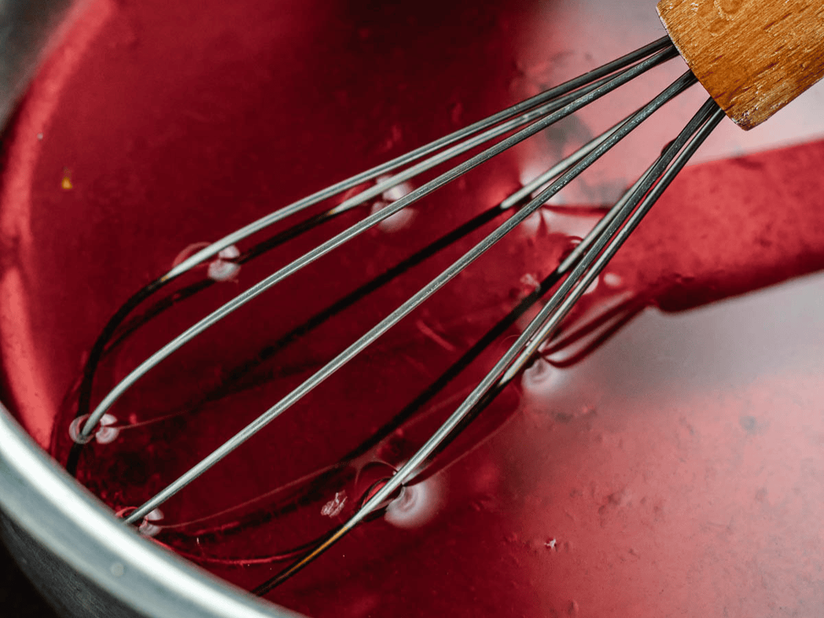 Heated syrup in pan with whisk.