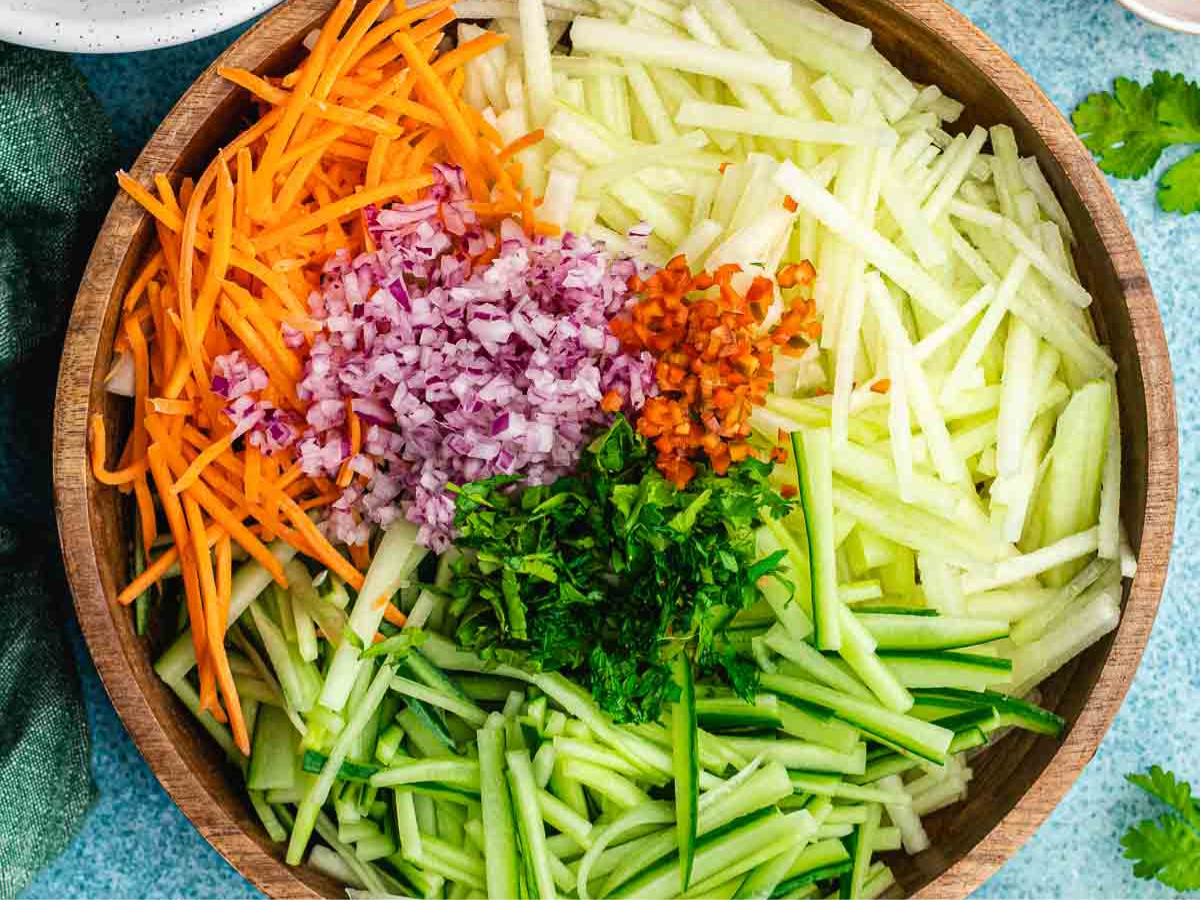 Salad ingredients separate in bowl, not yet mixed.