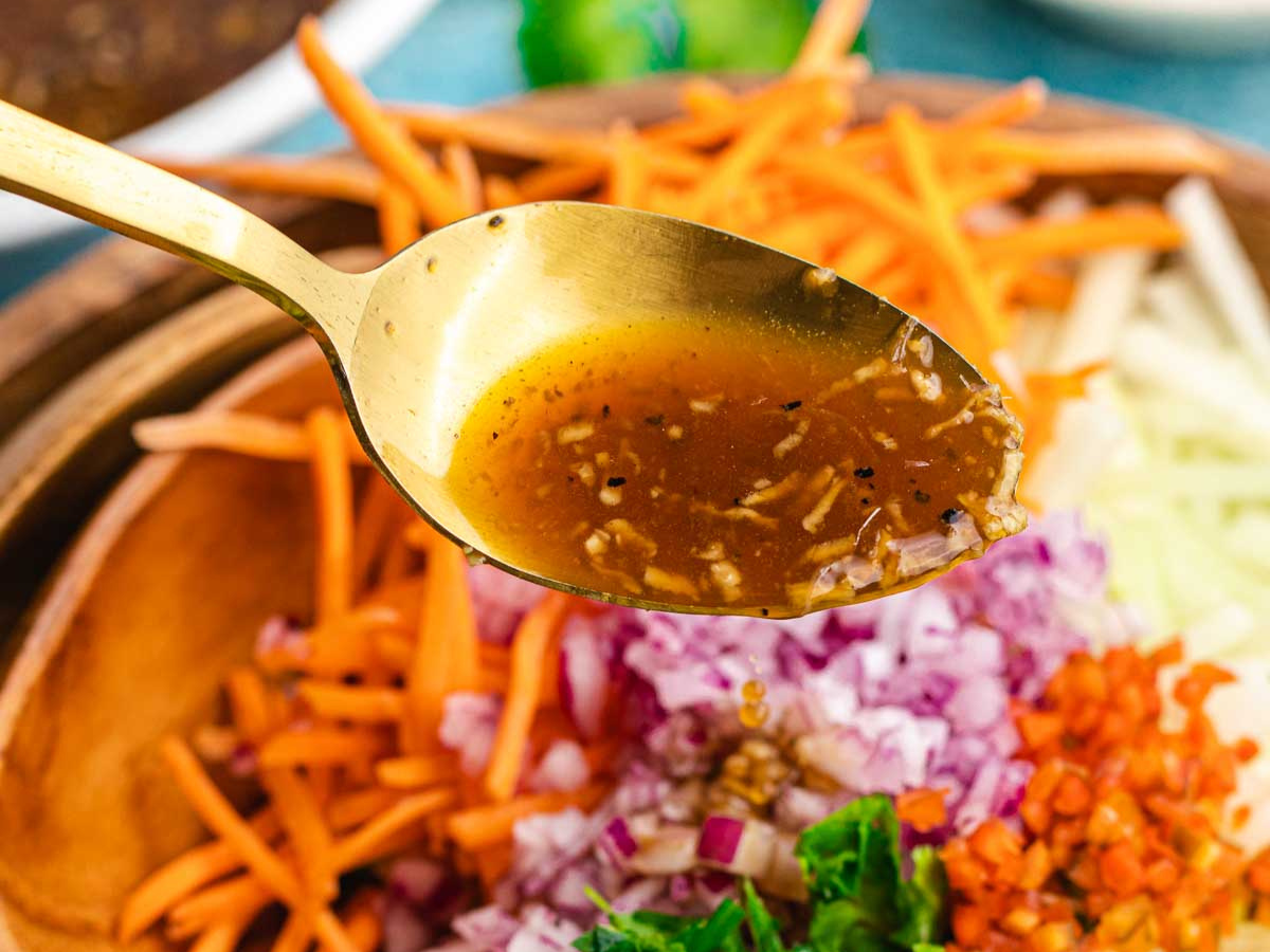 Dressing being poured onto salad.