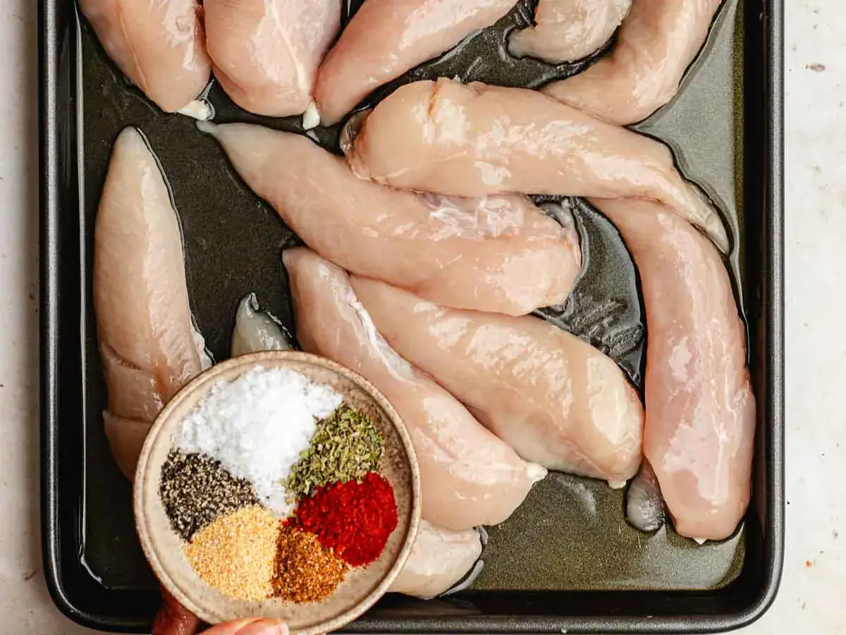 Raw poultry on baking sheet, about to be seasoned.