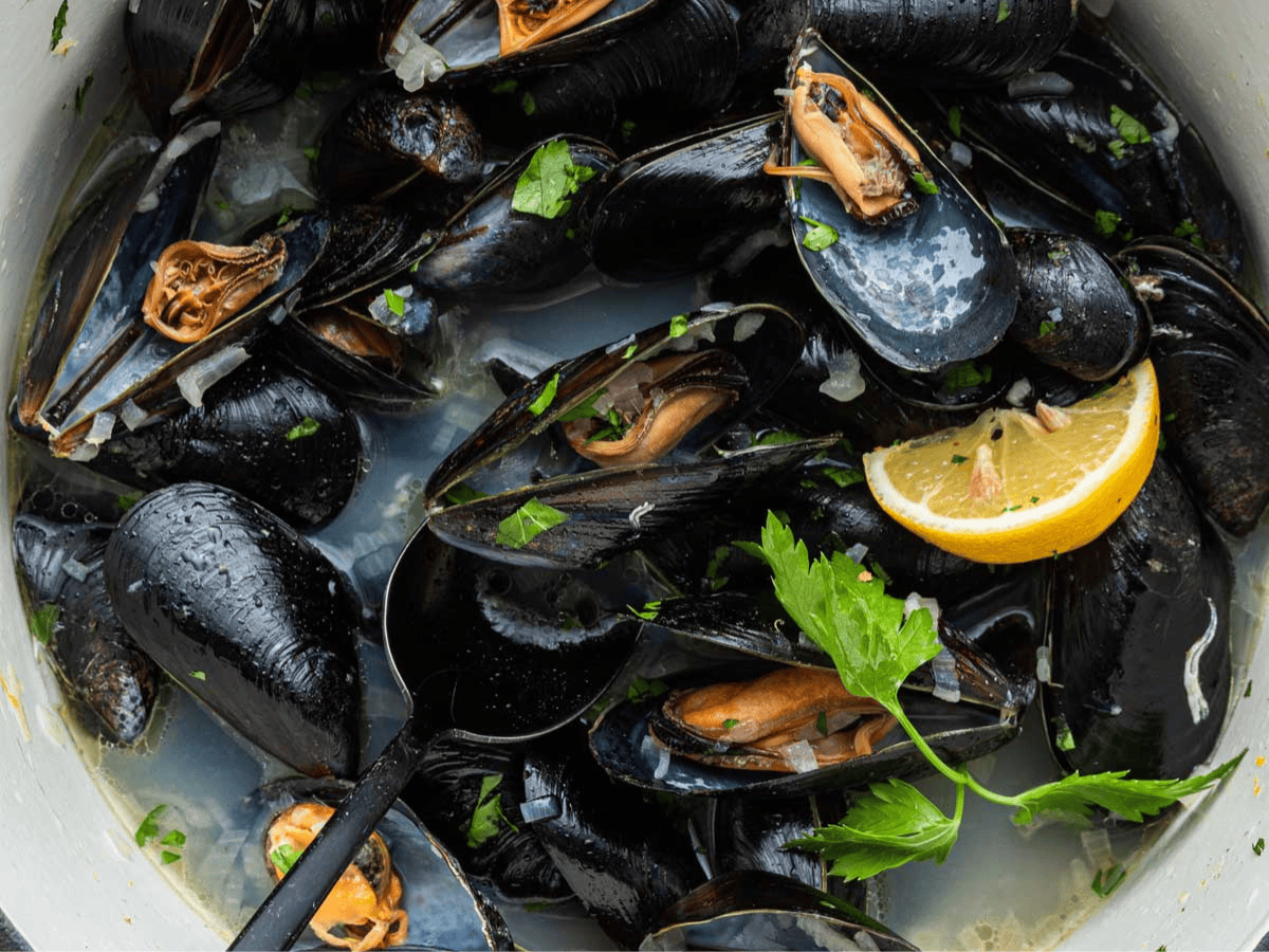 Pot filled with steamed mussels in broth.