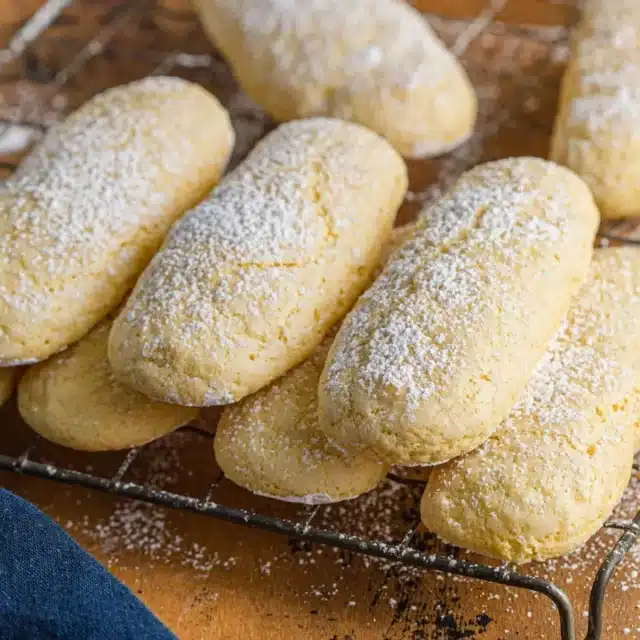 baked lady finger cookies piled on wire rack
