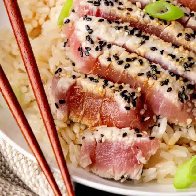 Seared ahi on dinner plate with rice.