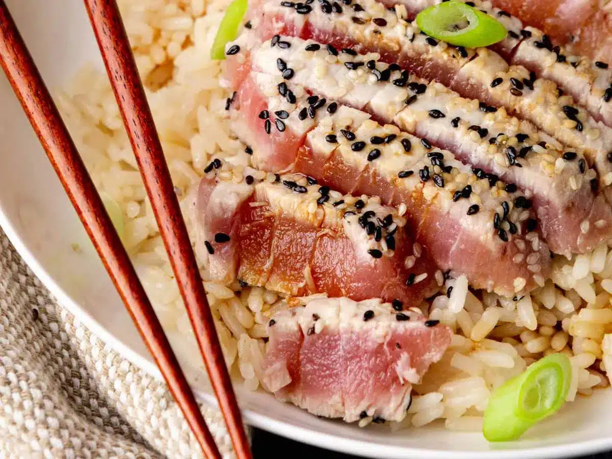 Seared ahi on dinner plate with rice.