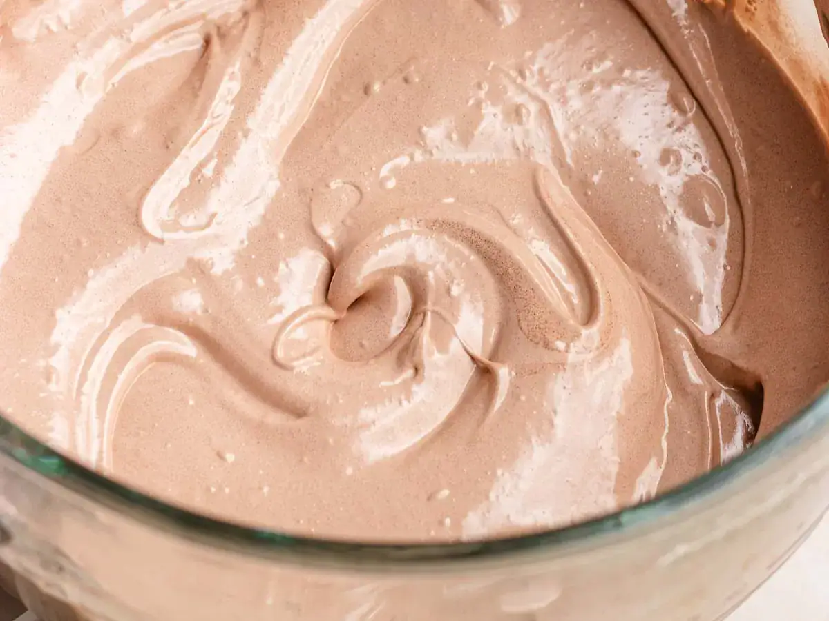 Gelatin, sugar, corn syrup, and cocoa whipped in bowl.