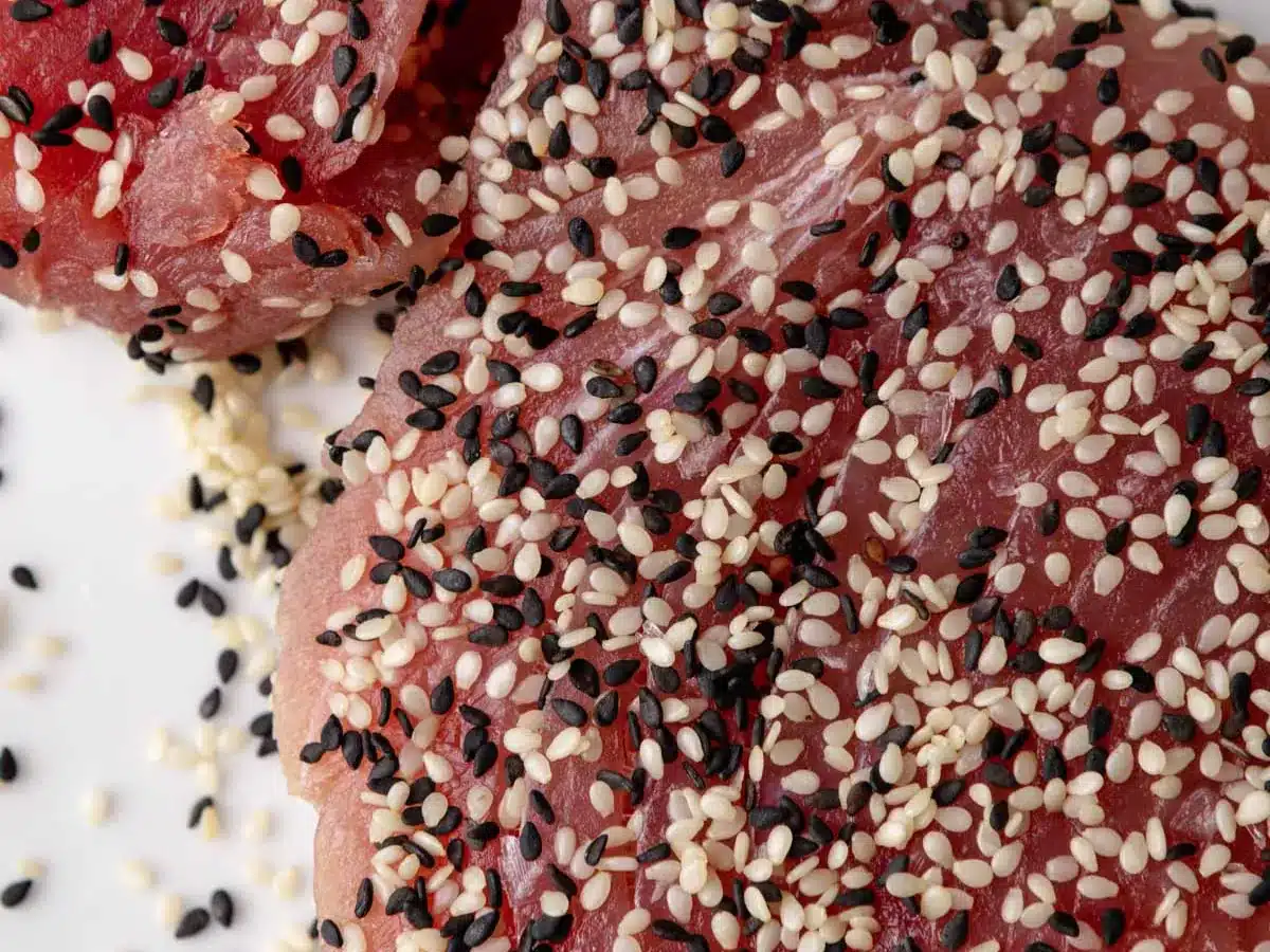 Raw sushi grade fish steak topped with sesame seeds.