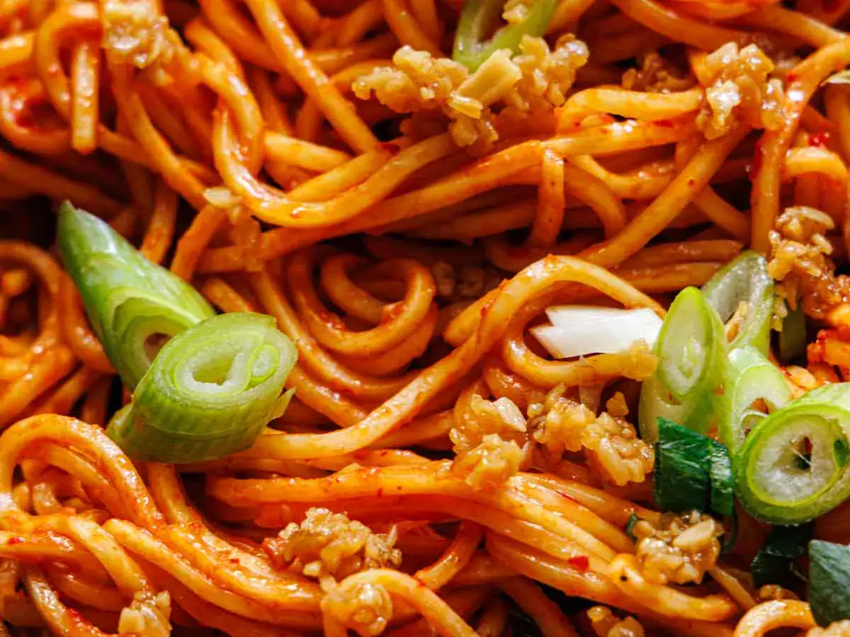 Close up of chow mein noodles coated in sauce.