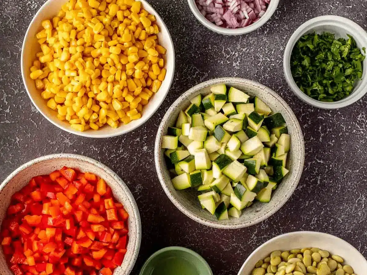 Diced vegetables and corn portioned out in separate bowls.