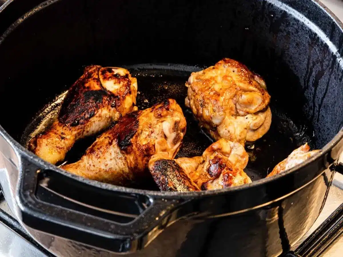 Browned drumsticks and thighs in pot.