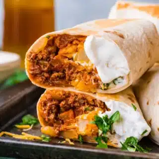 Burrito cut in half on dinner plate.