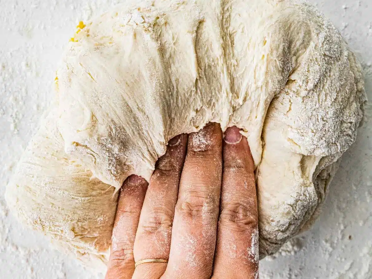 Dough being kneaded by hand.