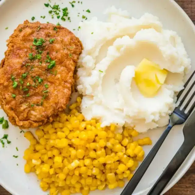 Dinner plate with pork, corn, and mashed potatoes.