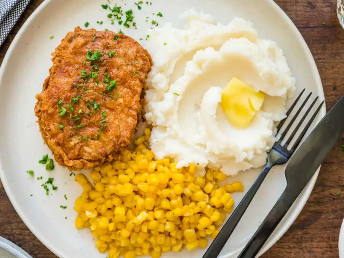 Dinner plate with pork, corn, and mashed potatoes.