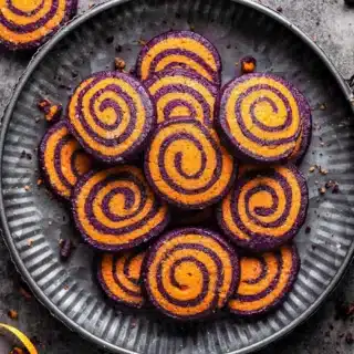 Plate full of sugar cookies with colorful swirls.