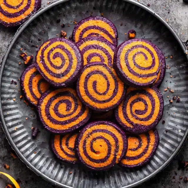 Plate full of sugar cookies with colorful swirls.