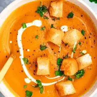 Bowl of creamy soup topped with croutons.