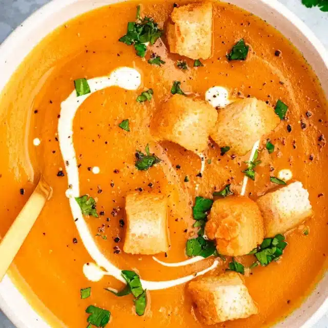 Bowl of creamy soup topped with croutons.