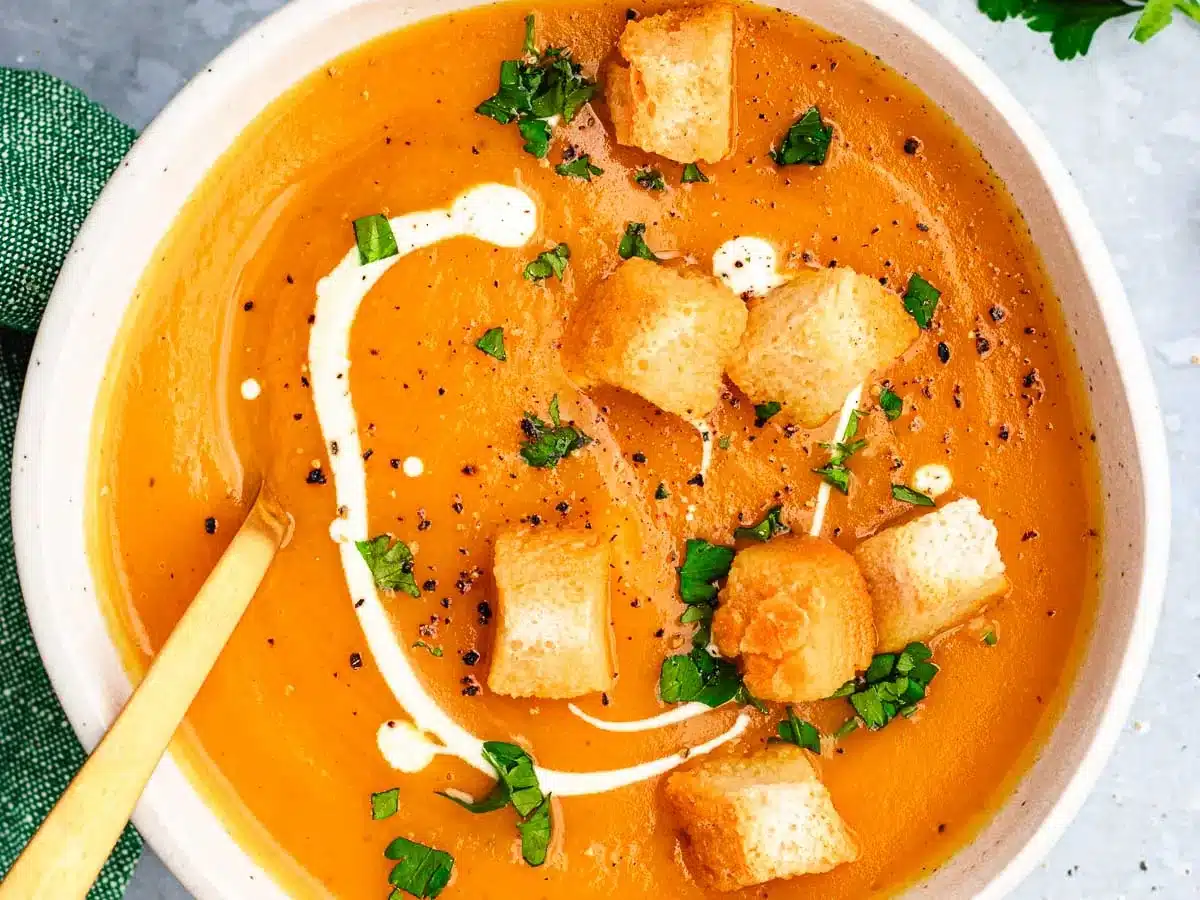 Bowl of creamy soup topped with croutons.