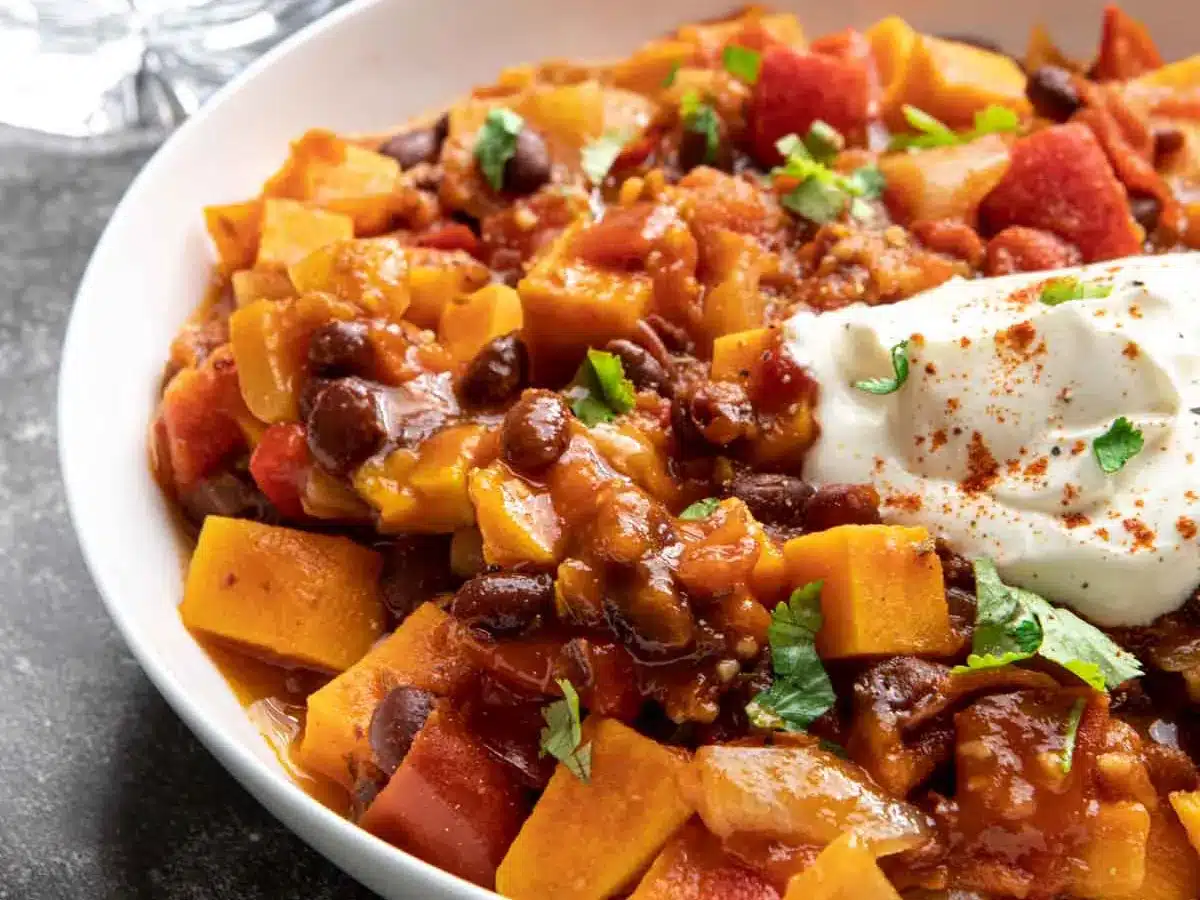 Bowl of vegetarian chili, topped with sour cream.