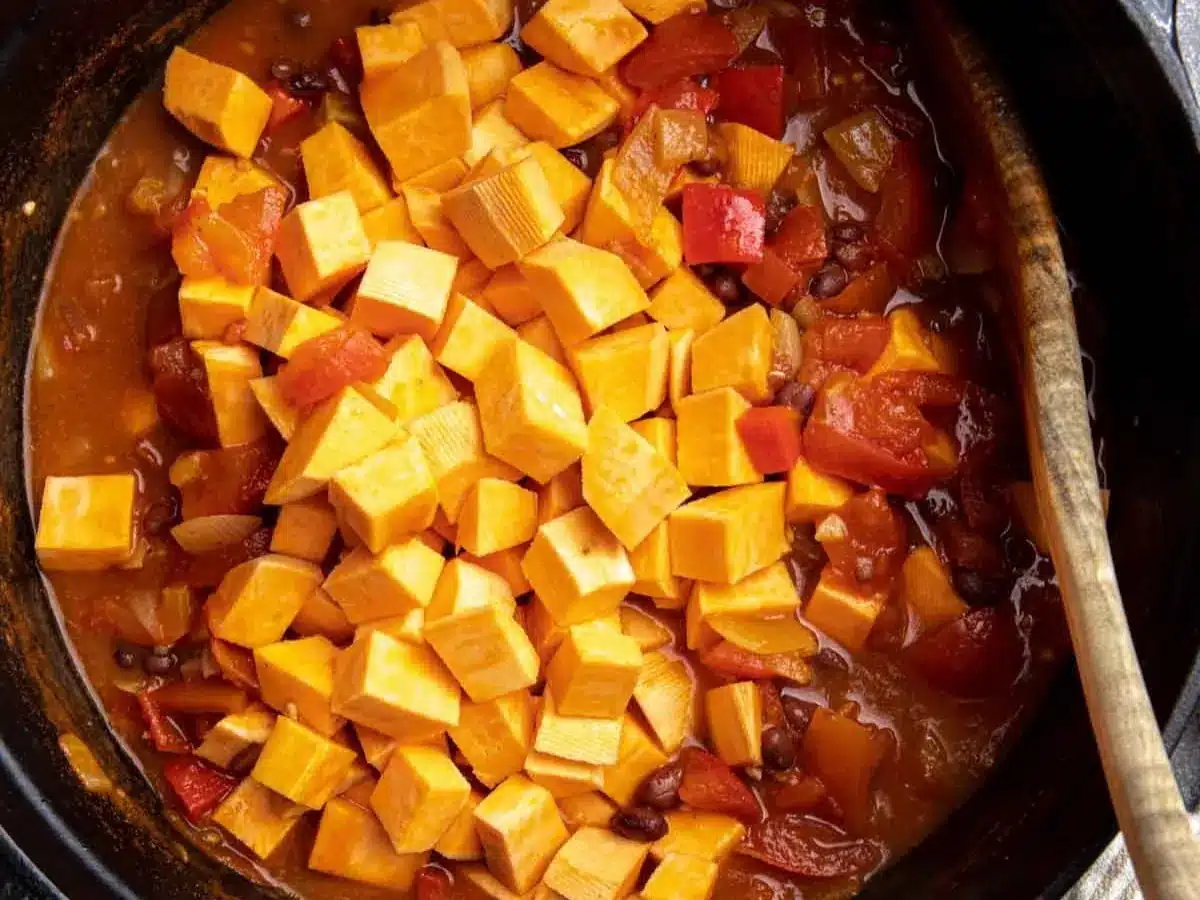 Cubed and diced vegetables cooking in large pot.