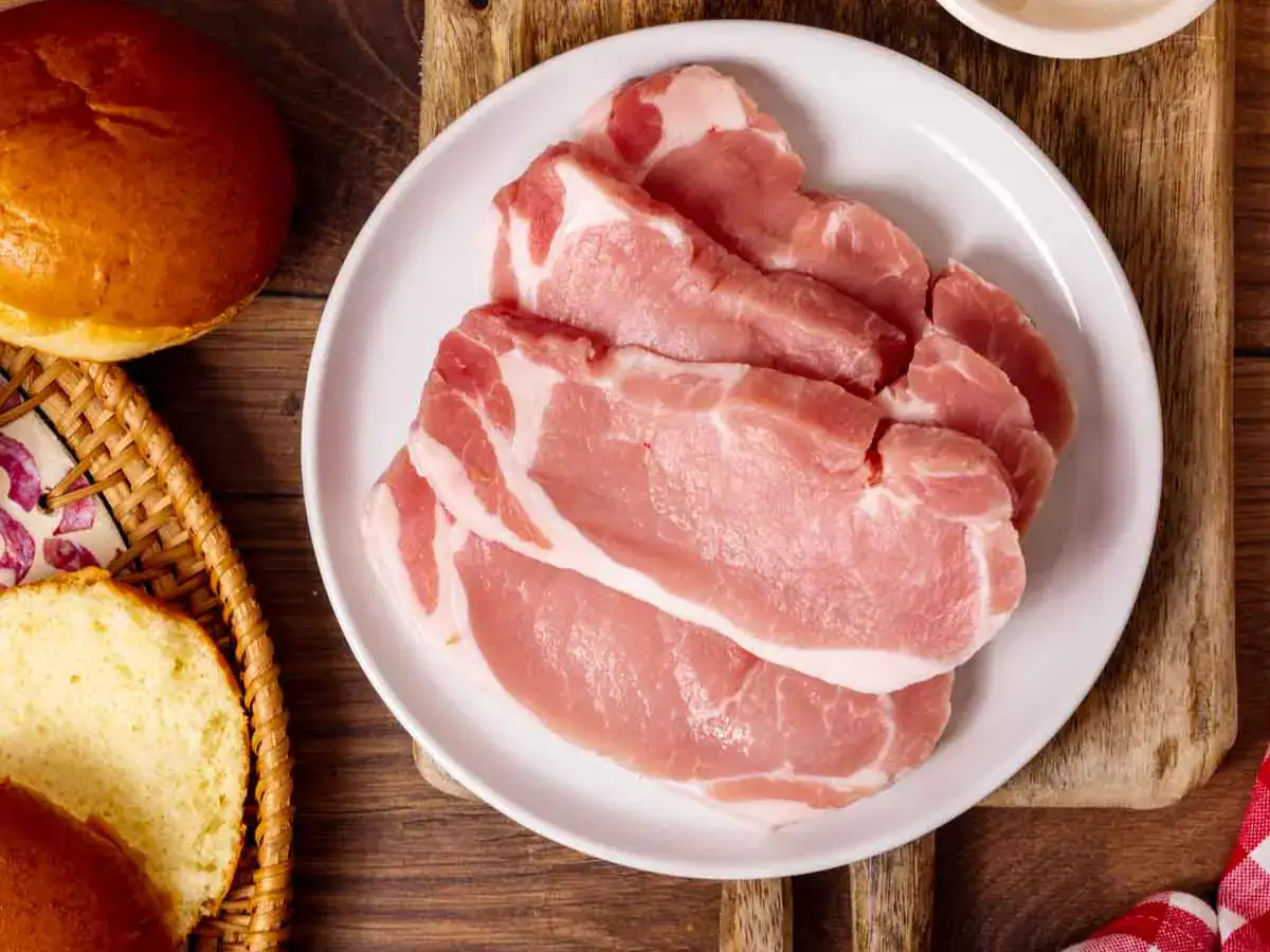 Raw pork on plate, ready for prep.