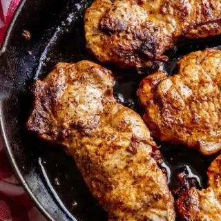 Pork frying up in a pan.